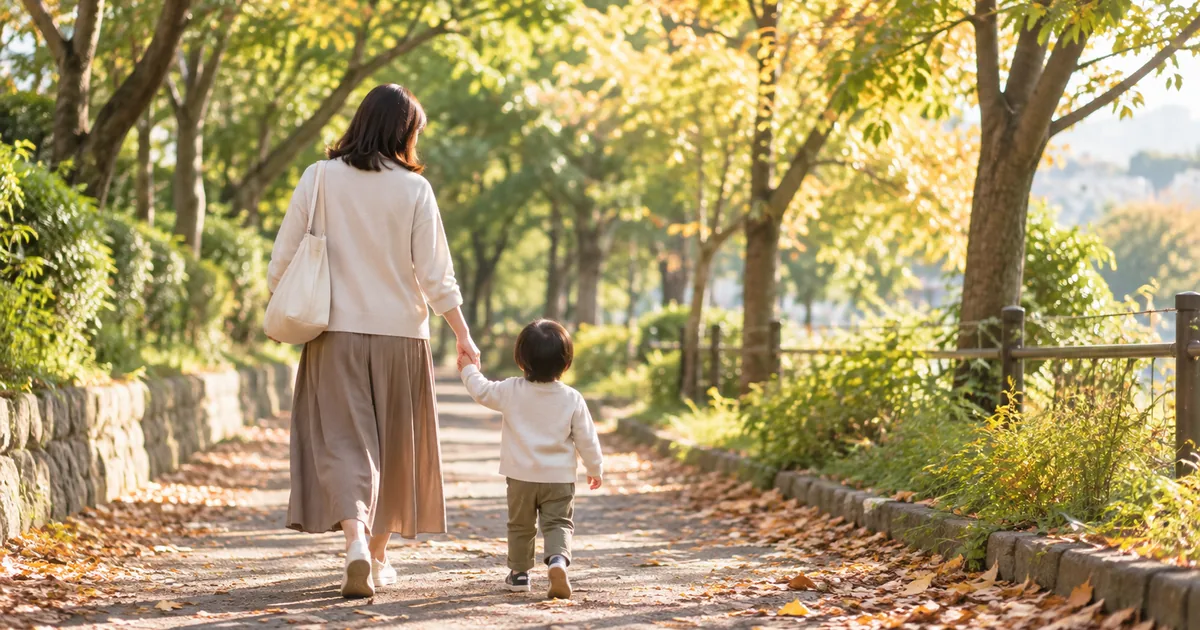 並木道を手をつないで歩く親子の後ろ姿のイメージ